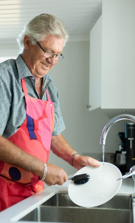 Man diskar en tallrik under rinnande kranvatten