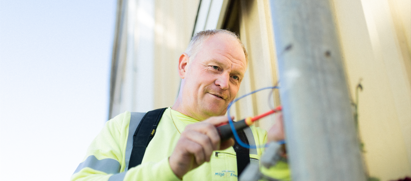 Man som fixar med ledningar i en gatulykta.